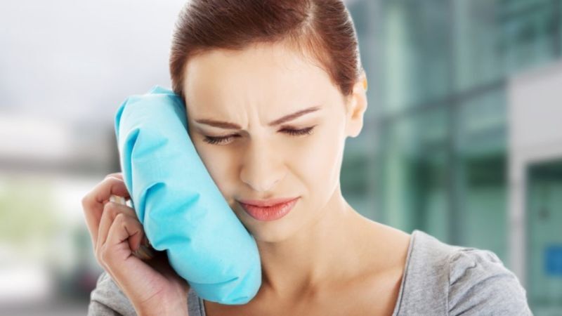 Chườm lạnh bên ngoài má giúp giảm đau khi niềng răng